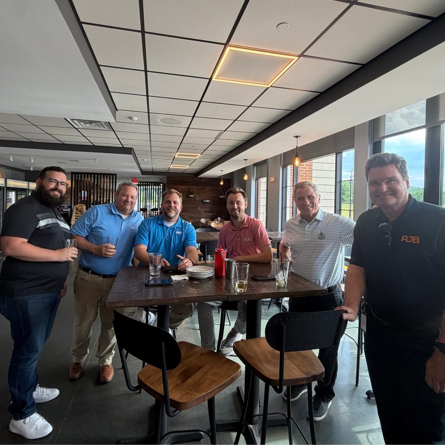 RJB team members gathered around a table at a happy hour