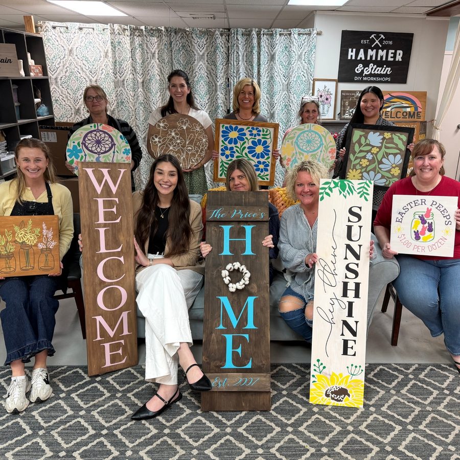 RJB team members holding hand-painted signs they made at a DIY workshop